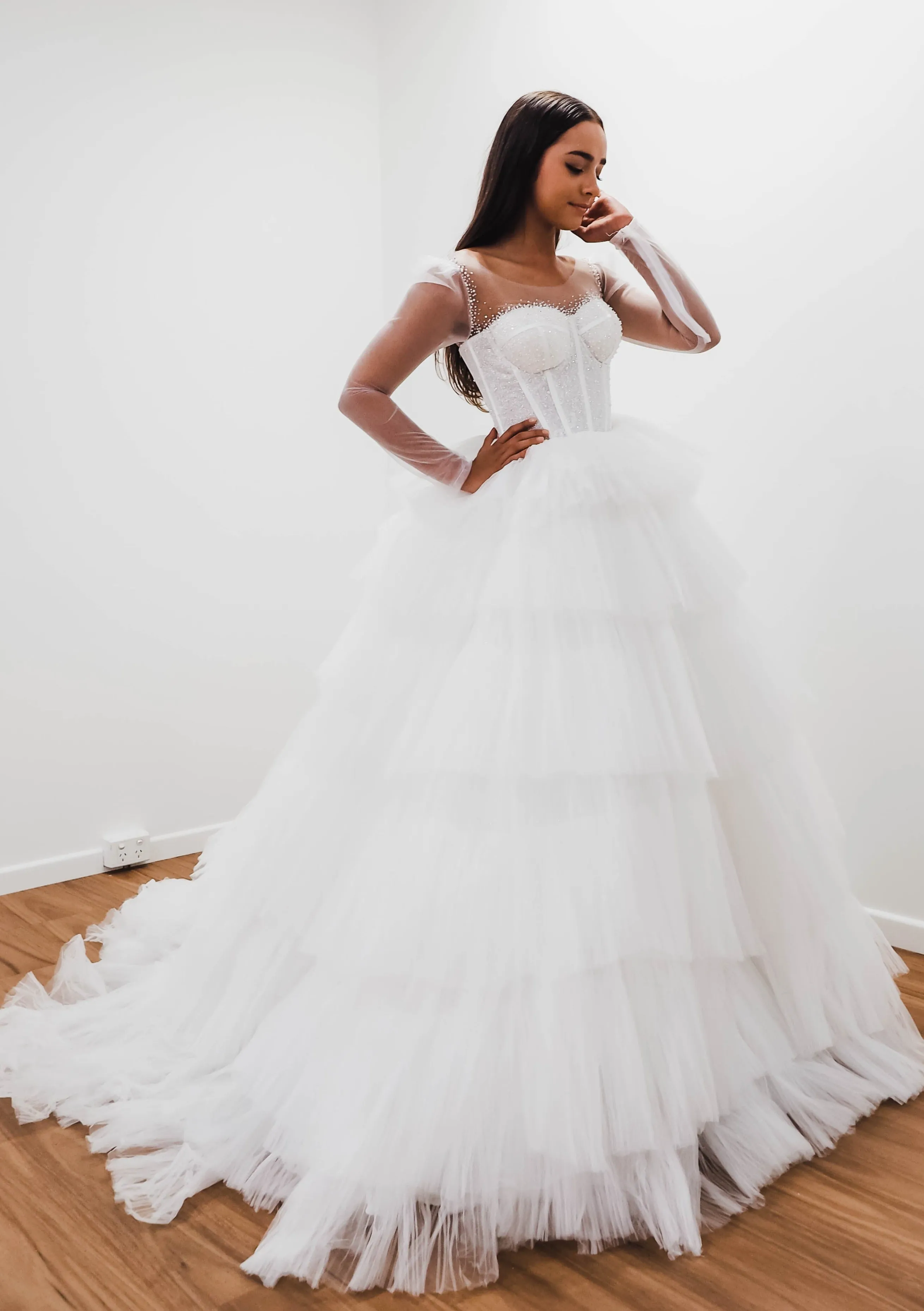 White wedding dress with a bushier top and a bushier puffy layered skirt.