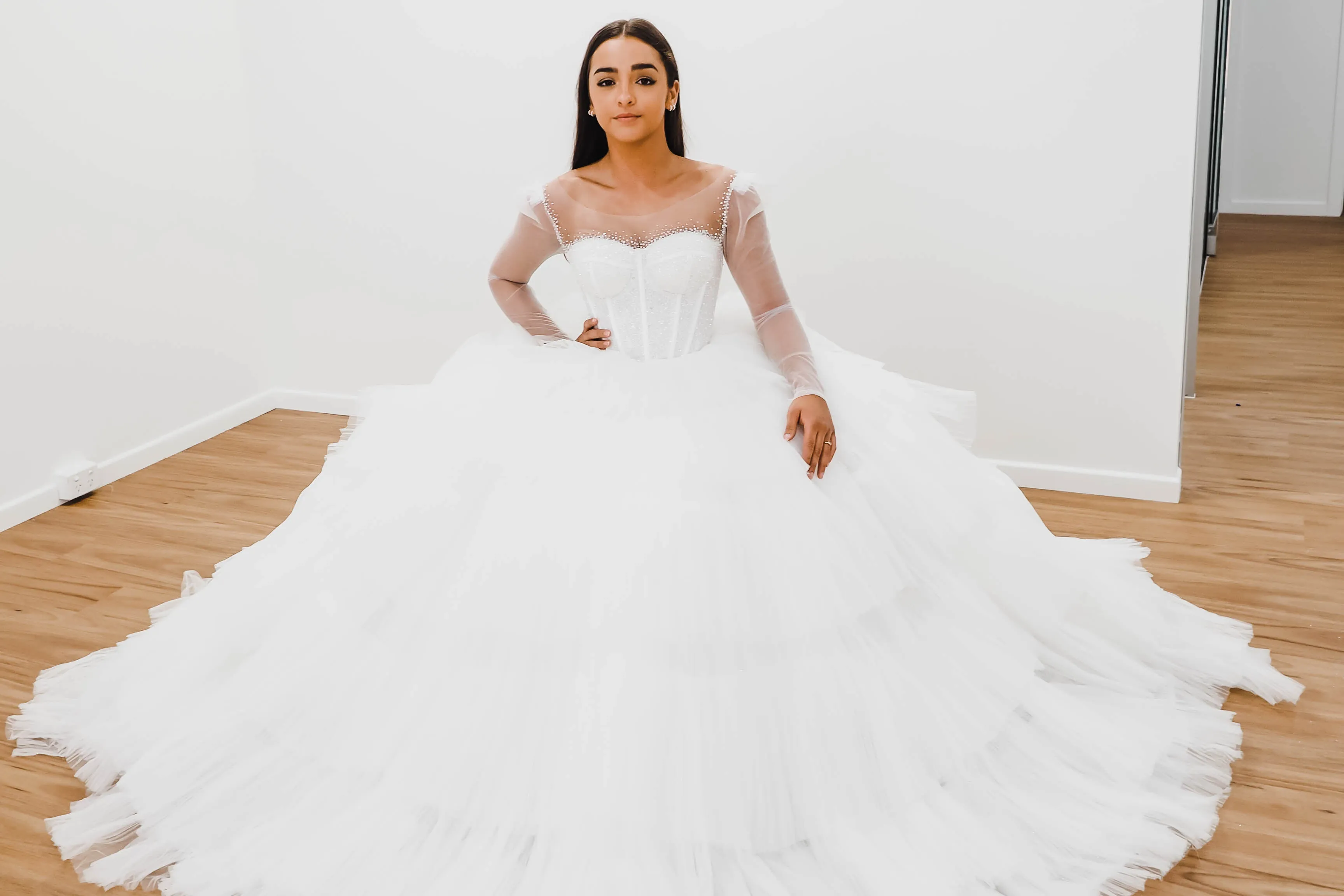 White wedding dress with a bushier top and a bushier puffy layered skirt.