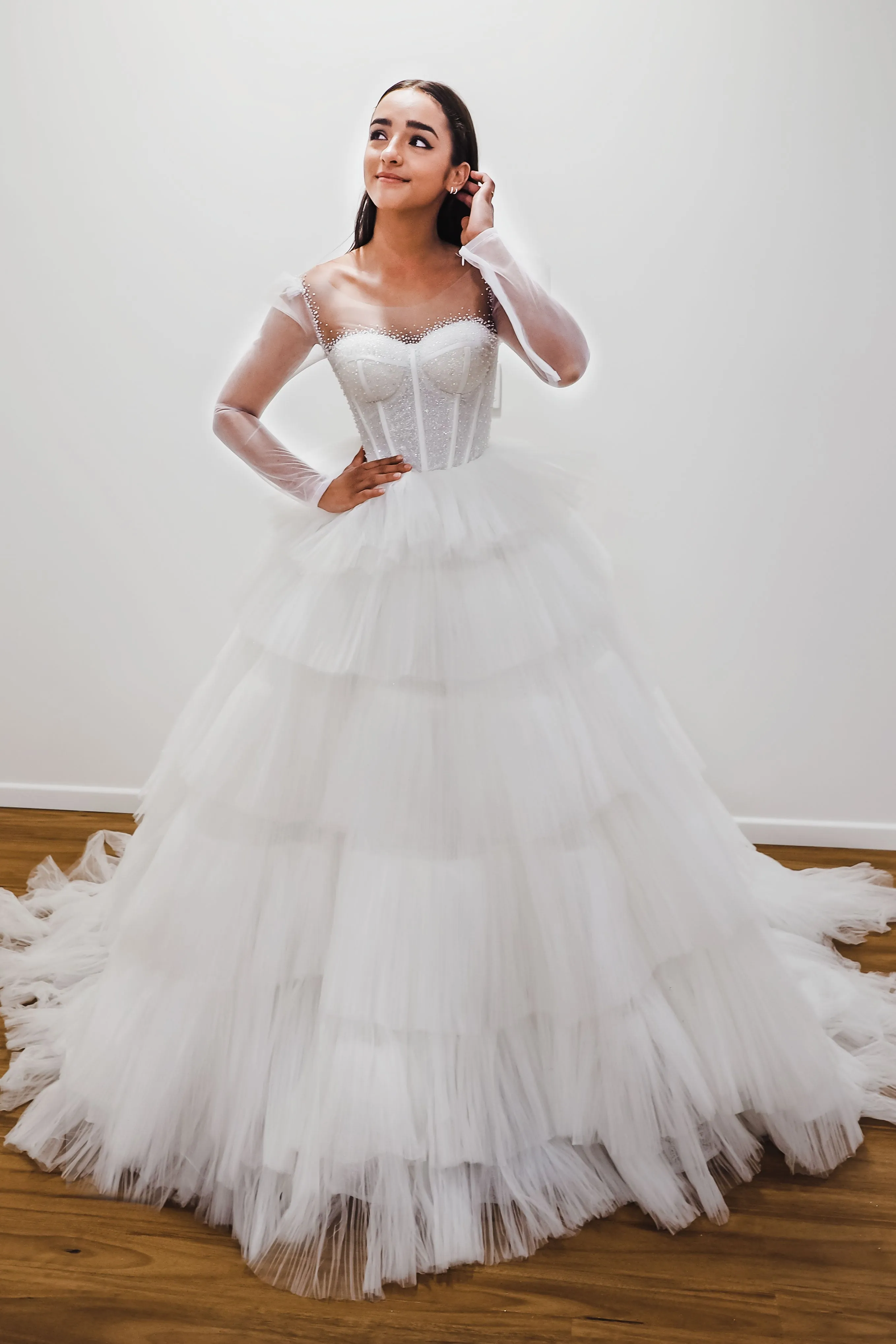 White wedding dress with a bushier top and a bushier puffy layered skirt.