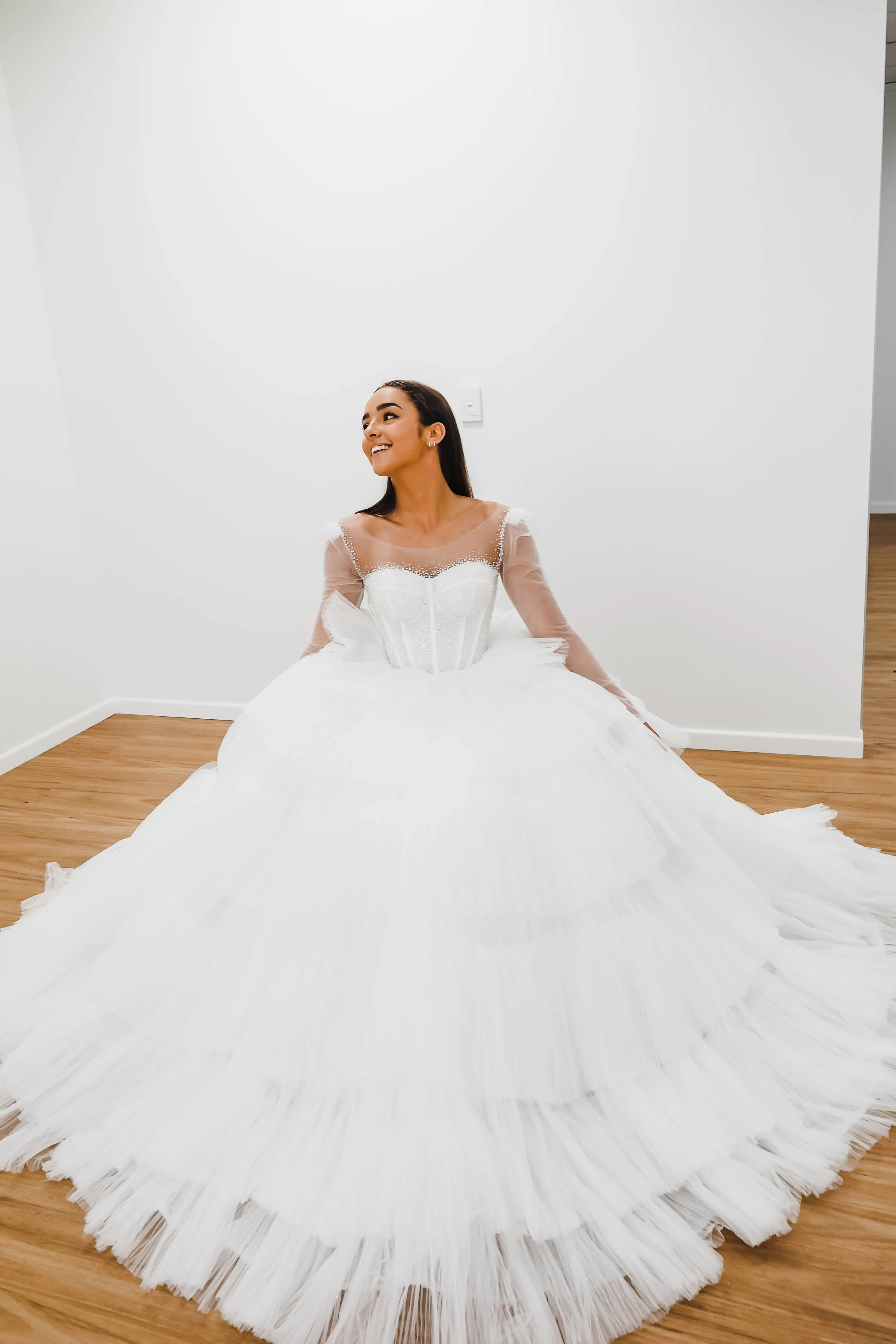 White wedding dress with a bushier top and a bushier puffy layered skirt.