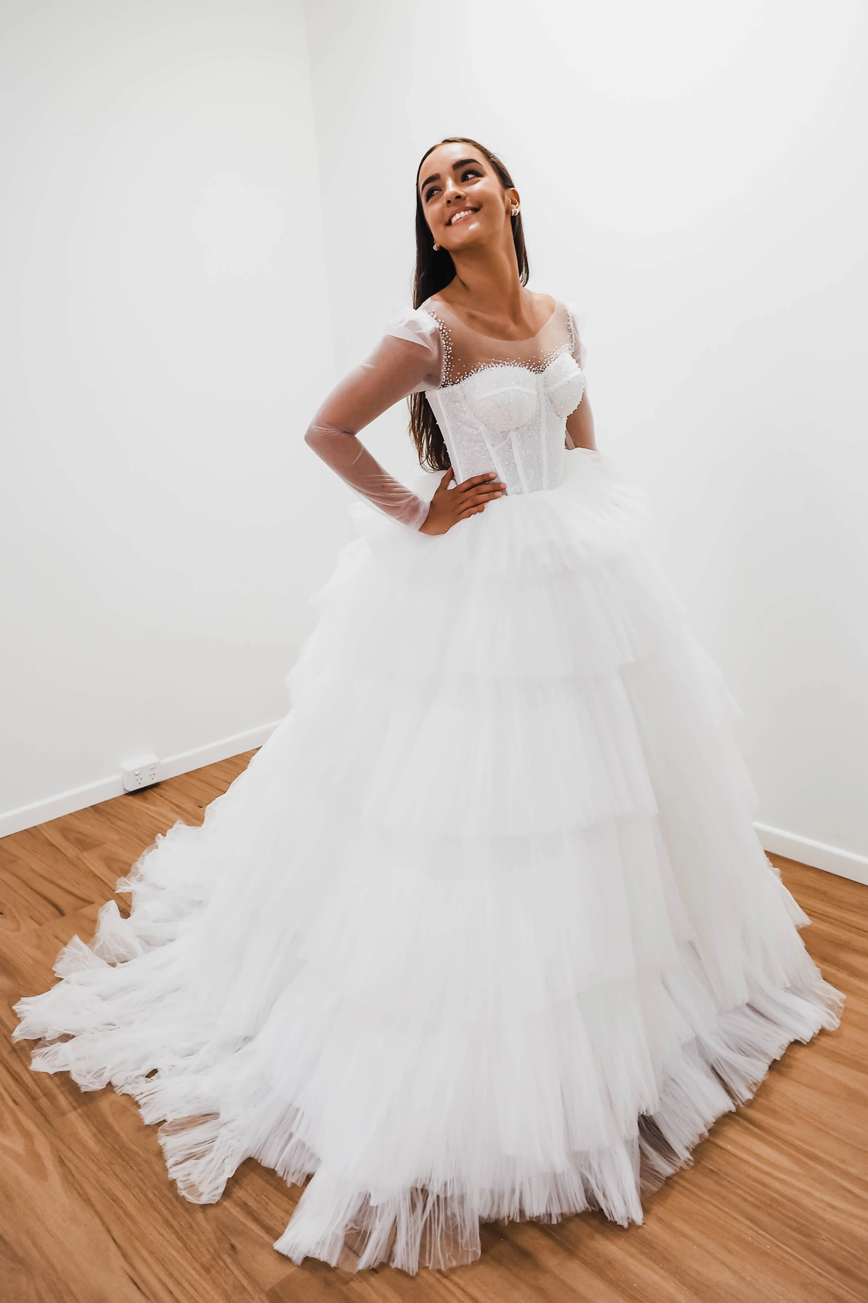 White wedding dress with a bushier top and a bushier puffy layered skirt.