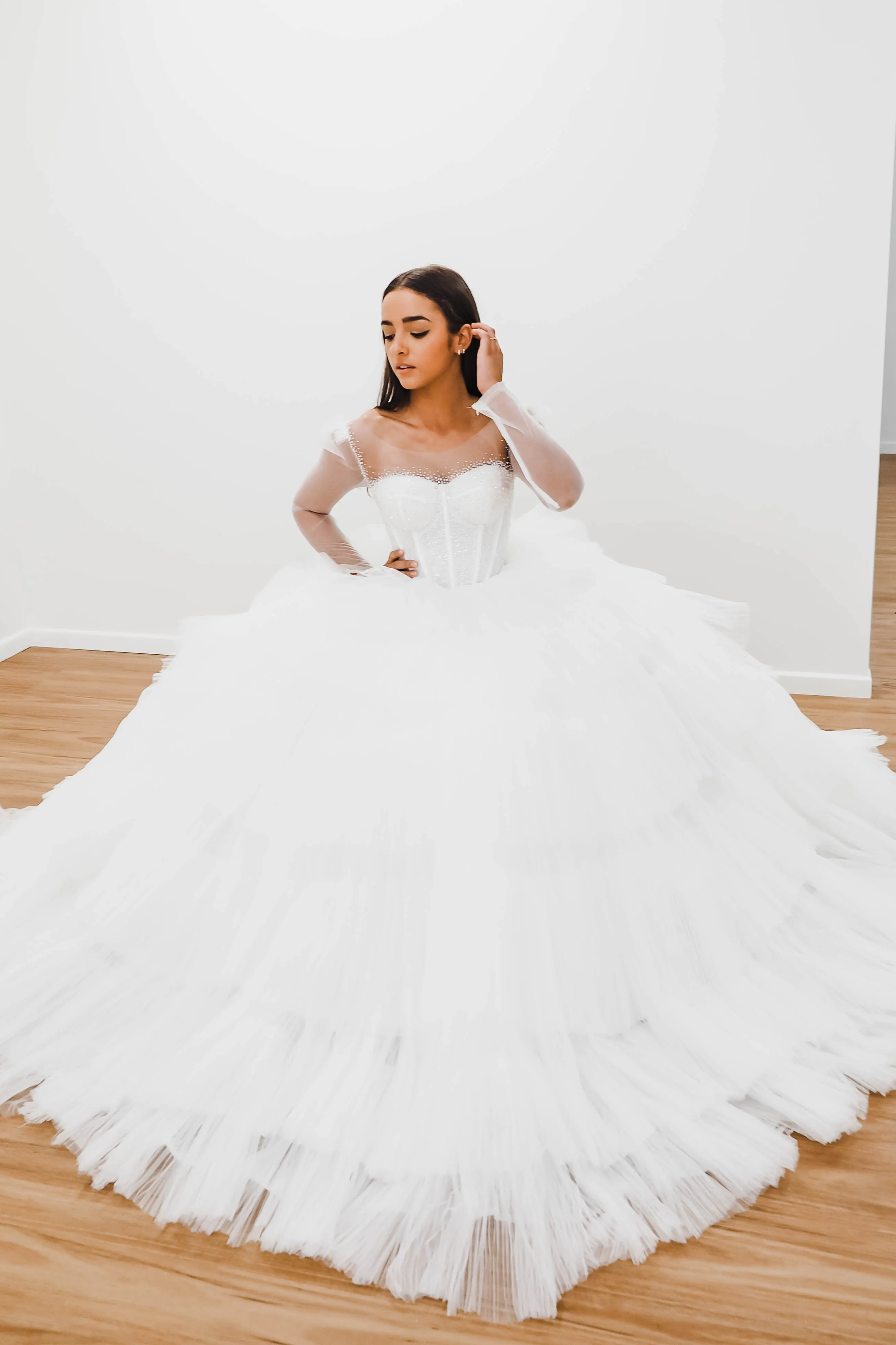 White wedding dress with a bushier top and a bushier puffy layered skirt.