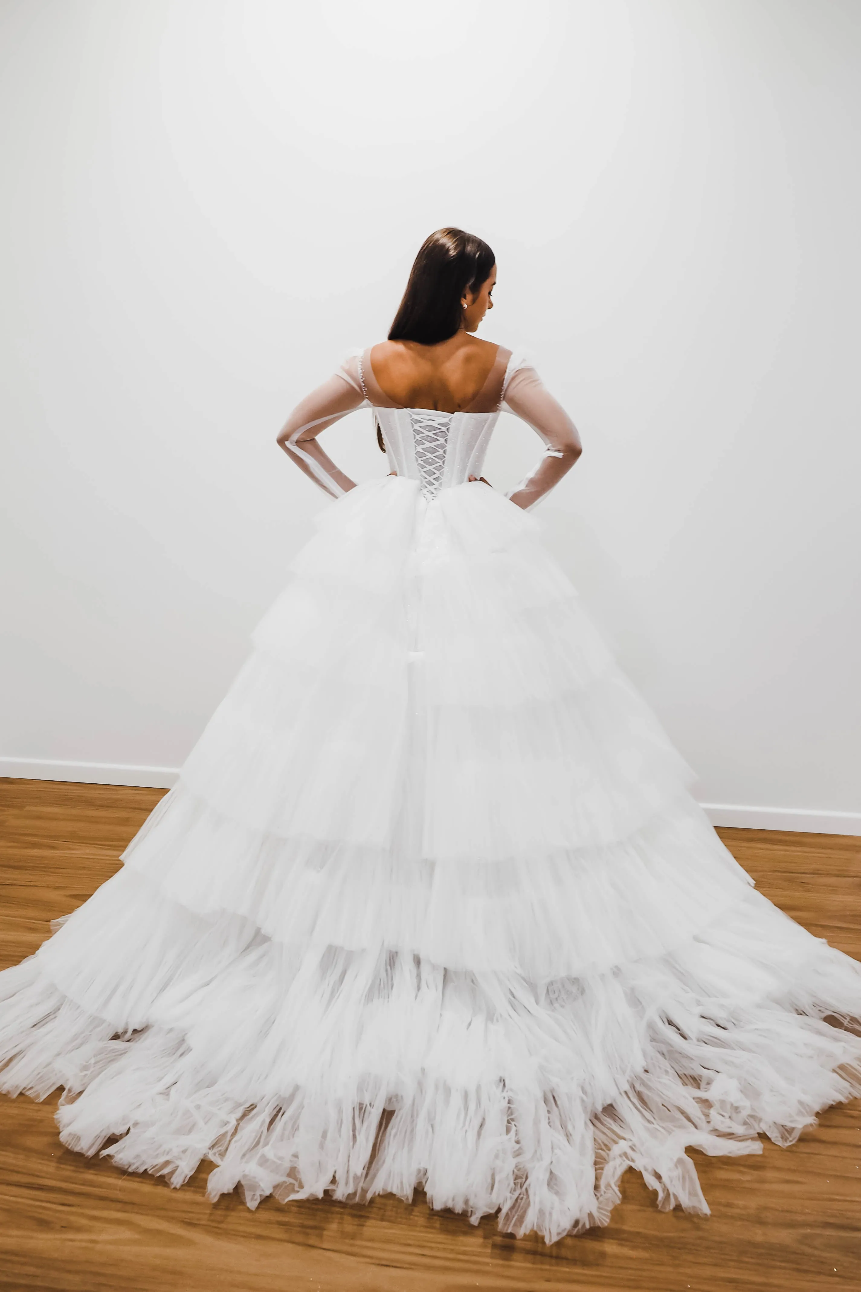 White wedding dress with a bushier top and a bushier puffy layered skirt.