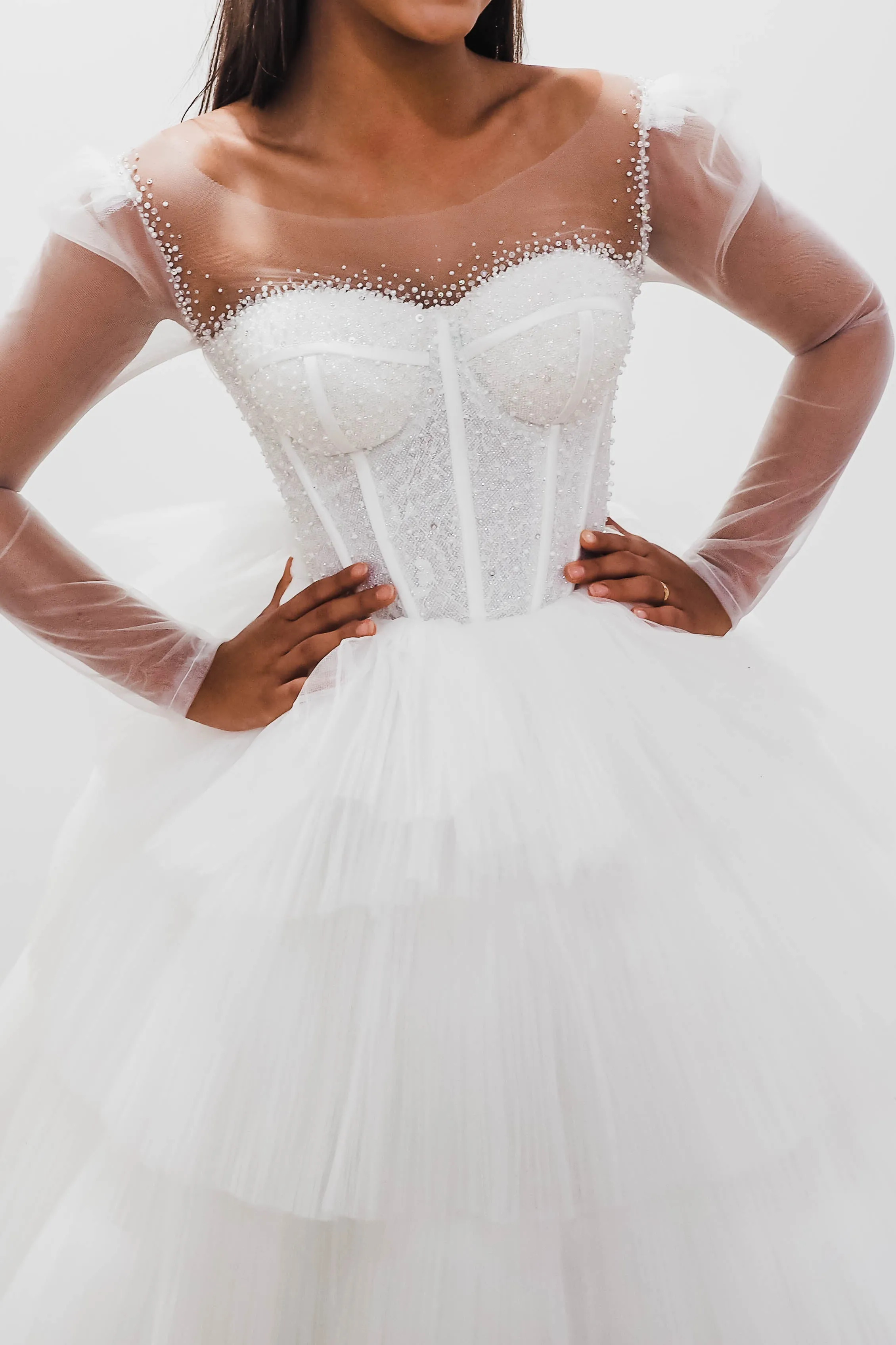 White wedding dress with a bushier top and a bushier puffy layered skirt.