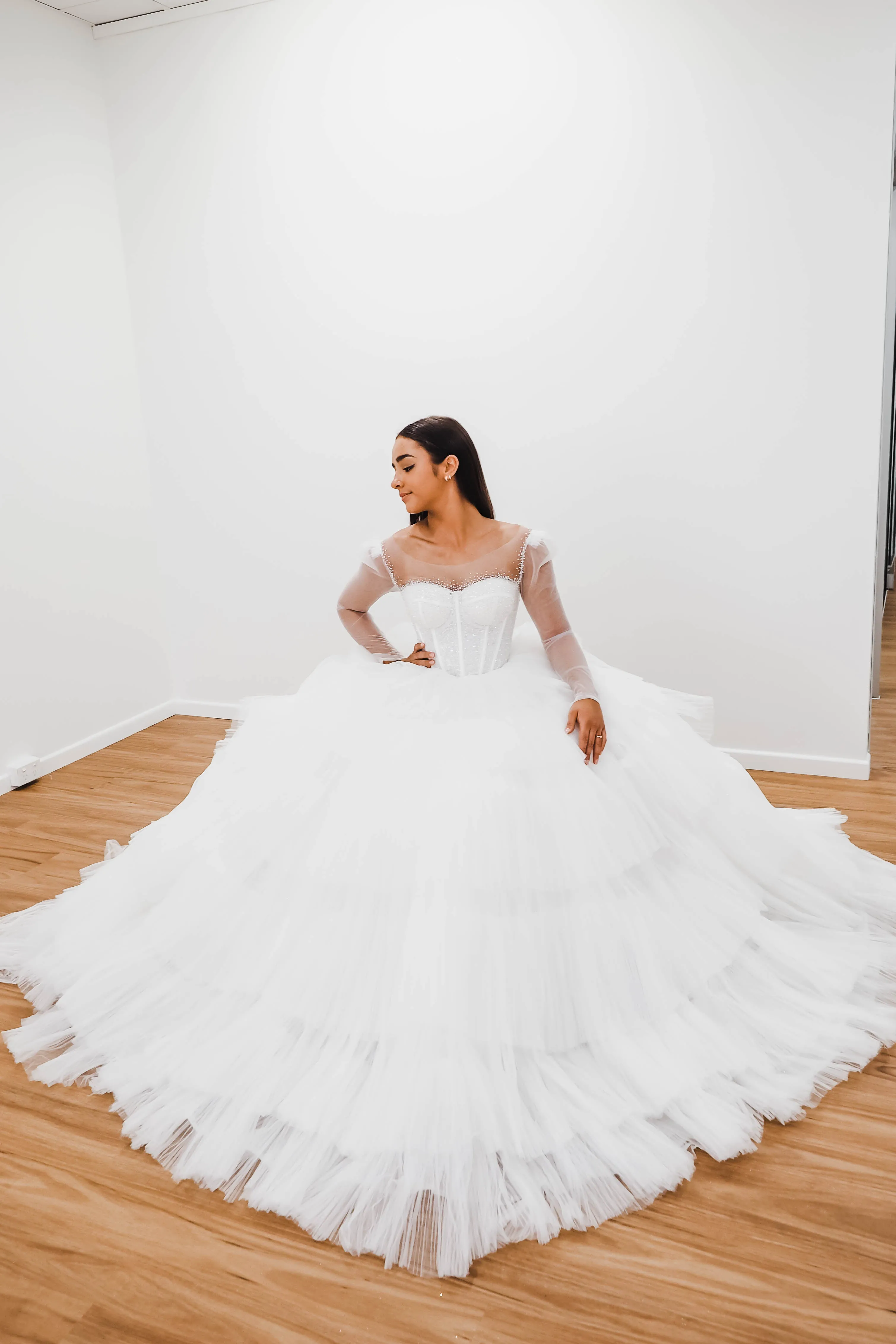 White wedding dress with a bushier top and a bushier puffy layered skirt.