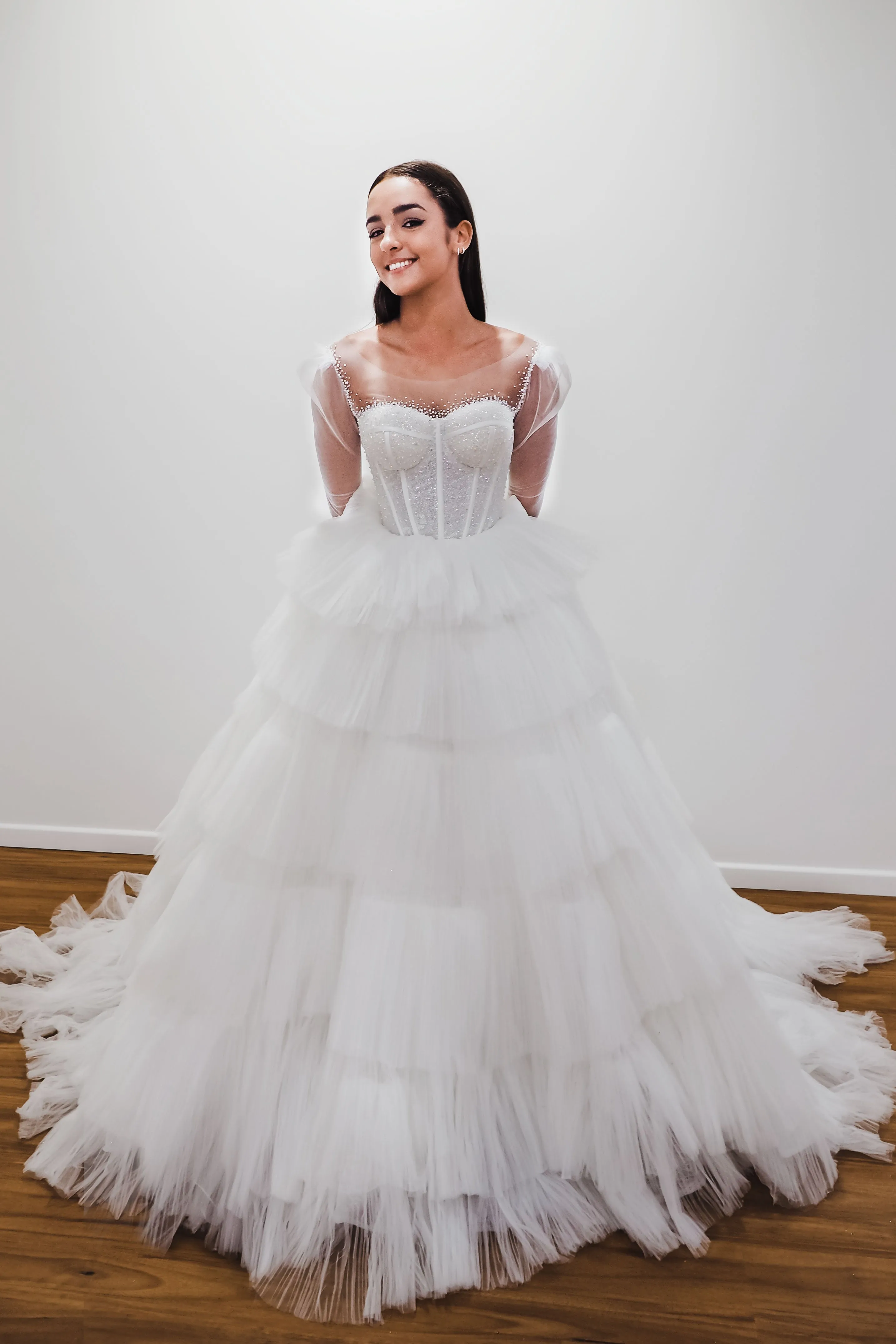 White wedding dress with a bushier top and a bushier puffy layered skirt.