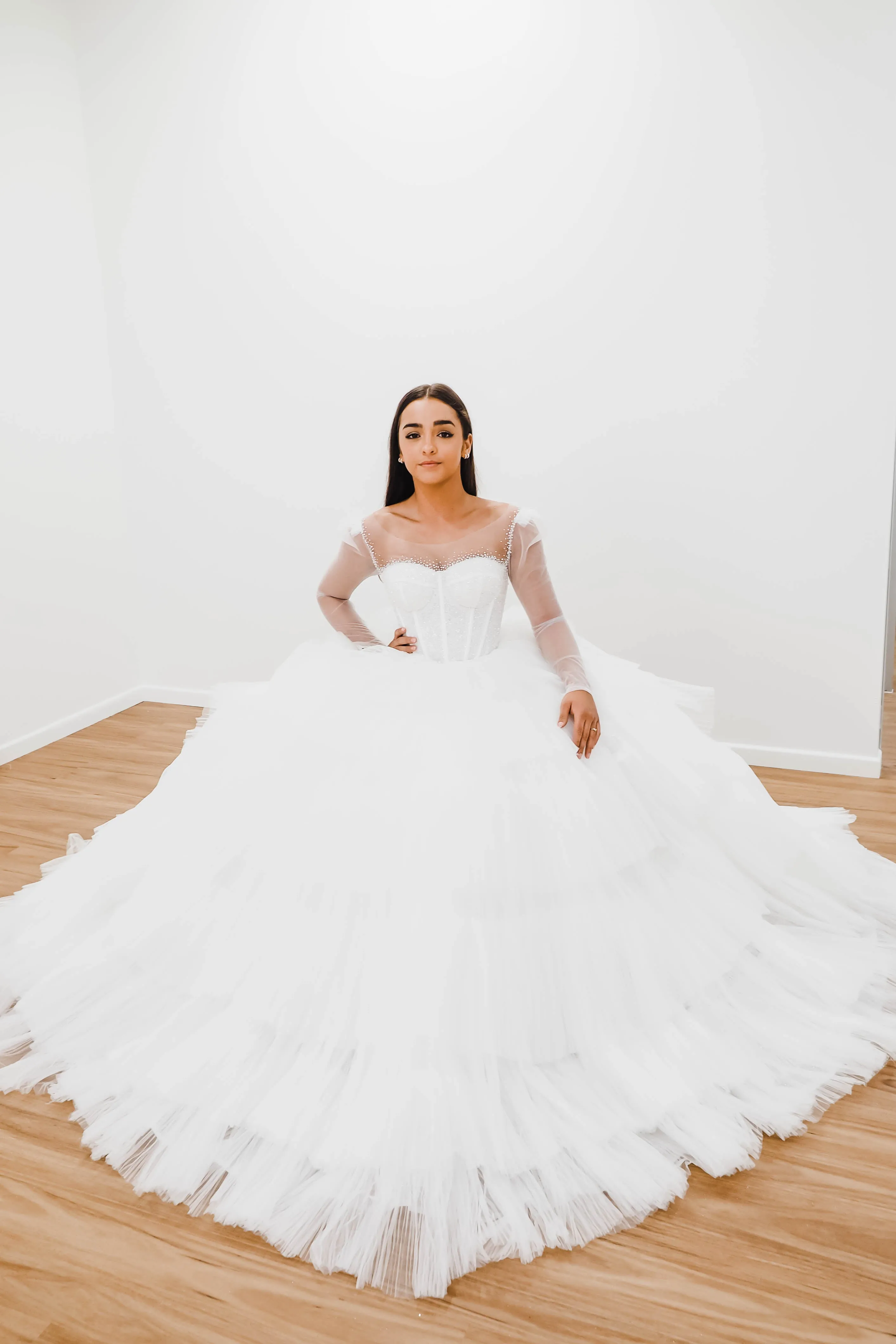 White wedding dress with a bushier top and a bushier puffy layered skirt.