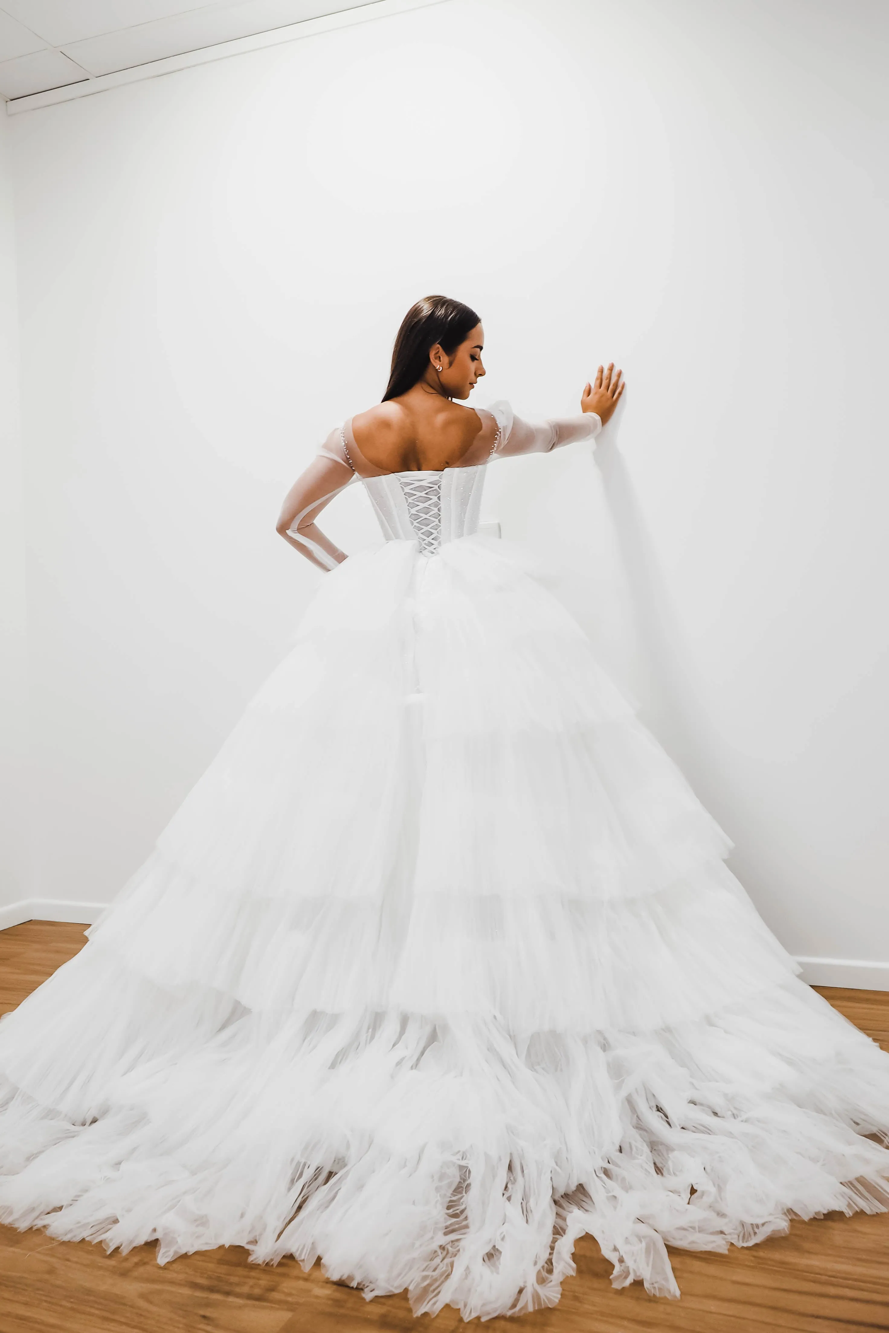 White wedding dress with a bushier top and a bushier puffy layered skirt.