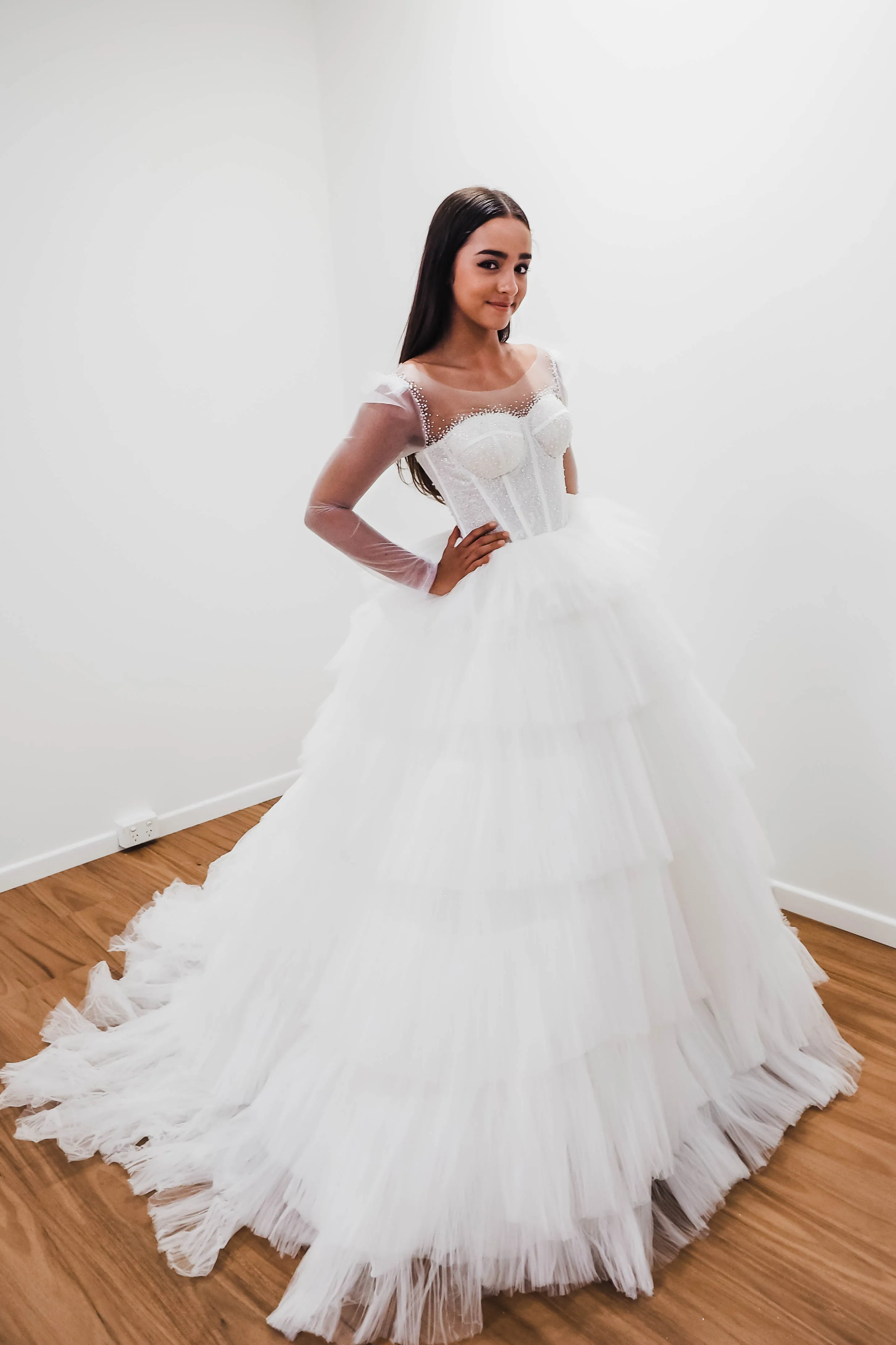 White wedding dress with a bushier top and a bushier puffy layered skirt.