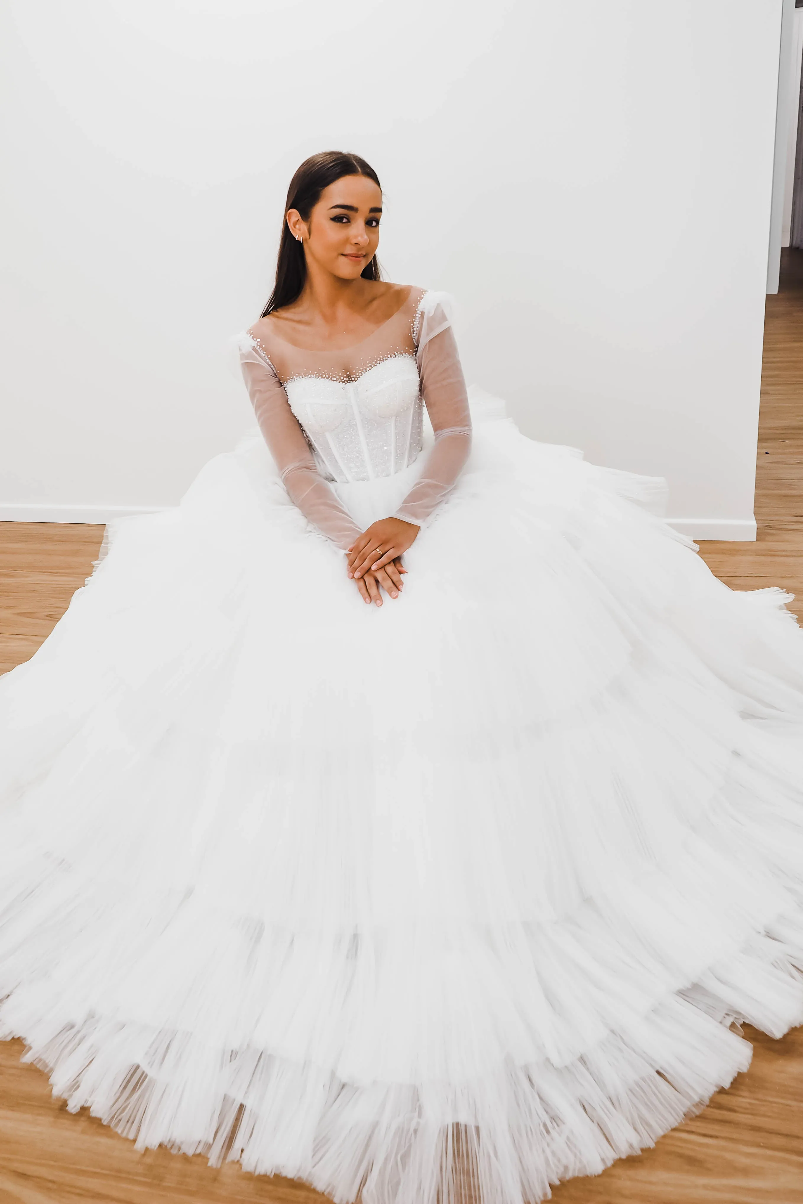 White wedding dress with a bushier top and a bushier puffy layered skirt.