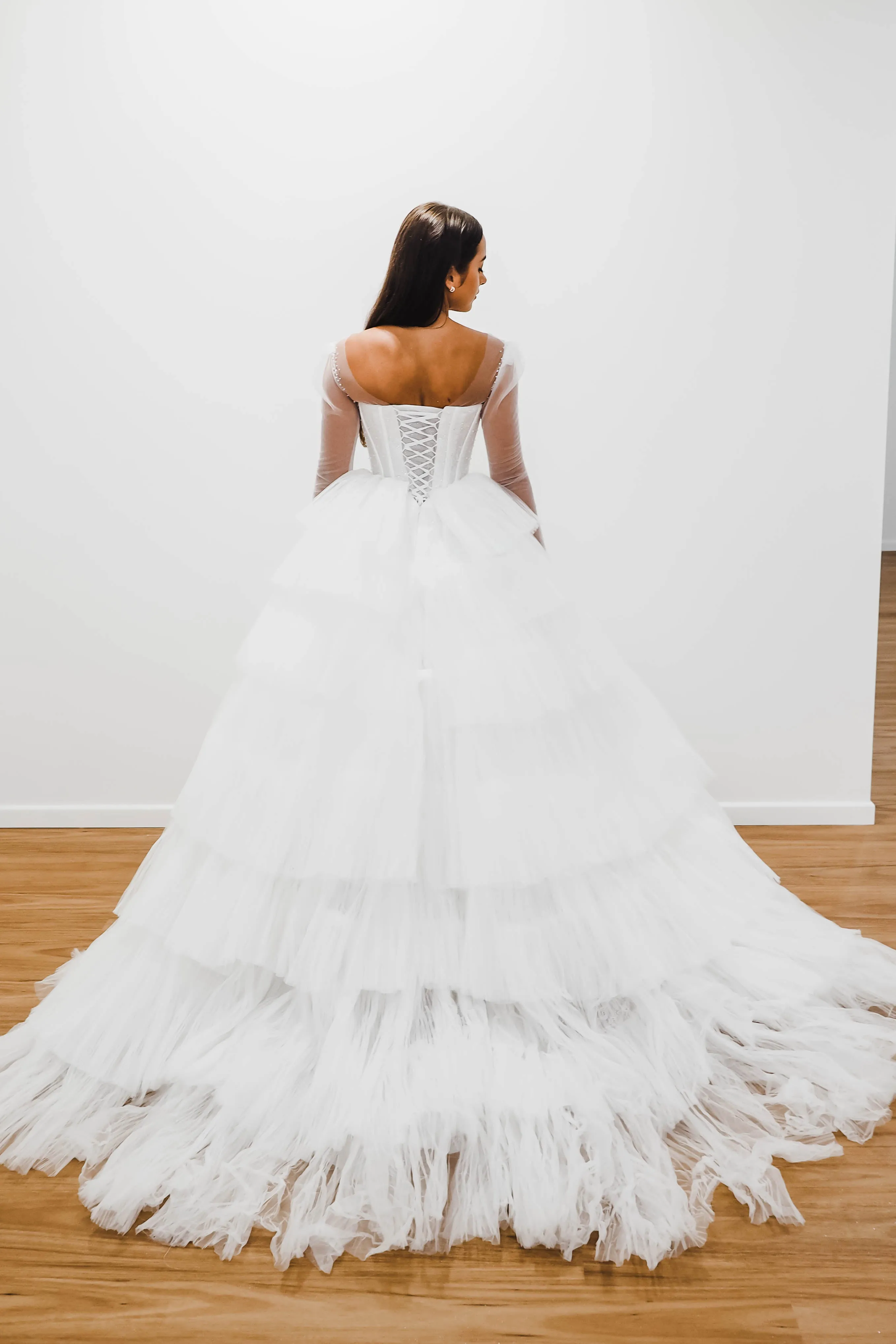 White wedding dress with a bushier top and a bushier puffy layered skirt.