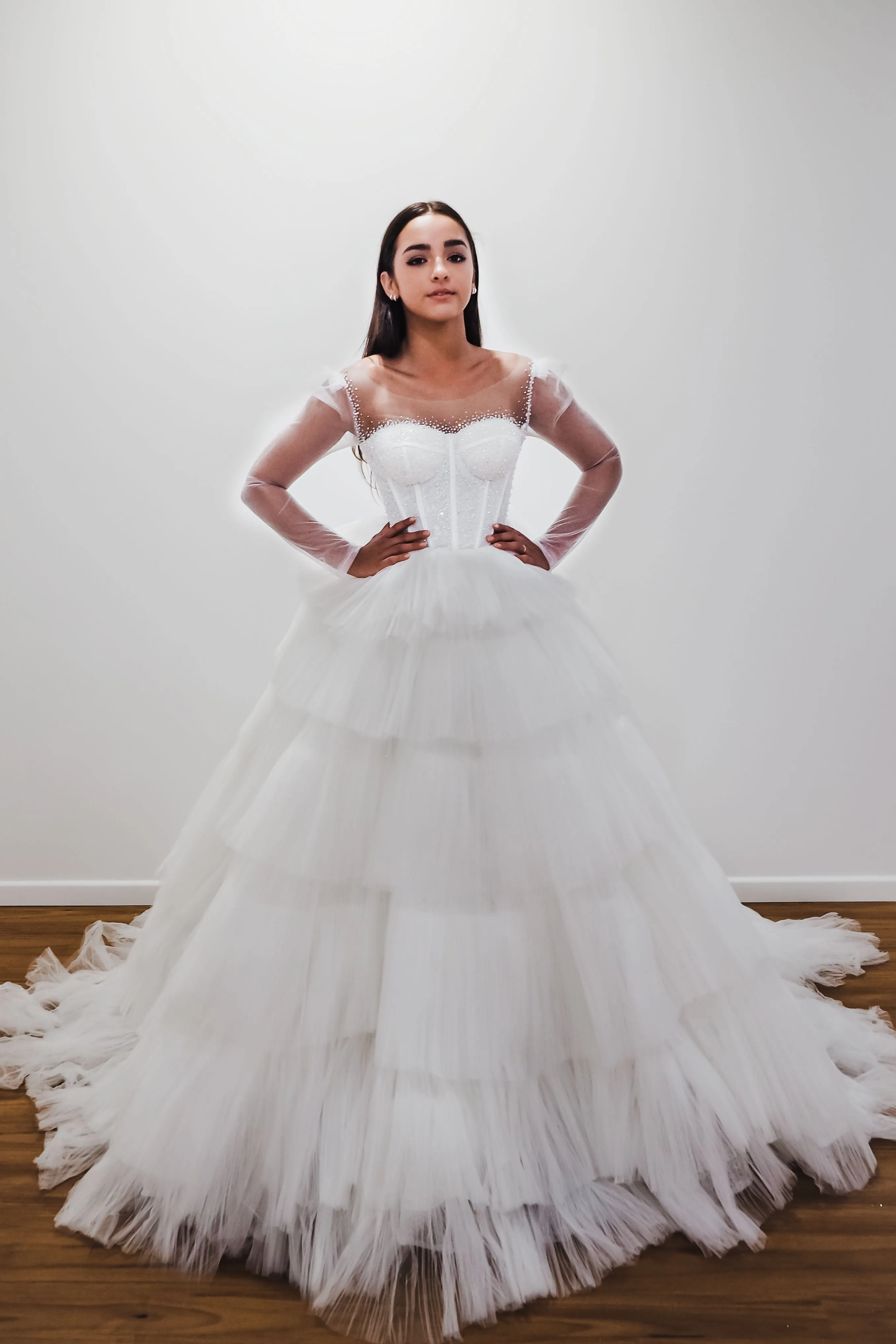 White wedding dress with a bushier top and a bushier puffy layered skirt.